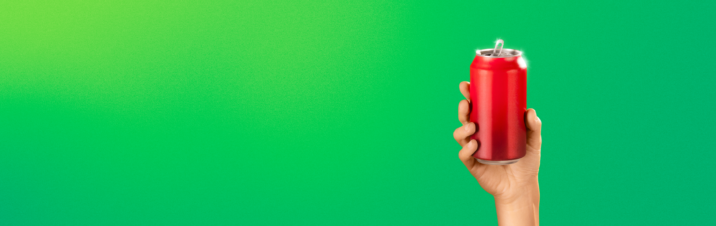 Hand holding red can against a green background