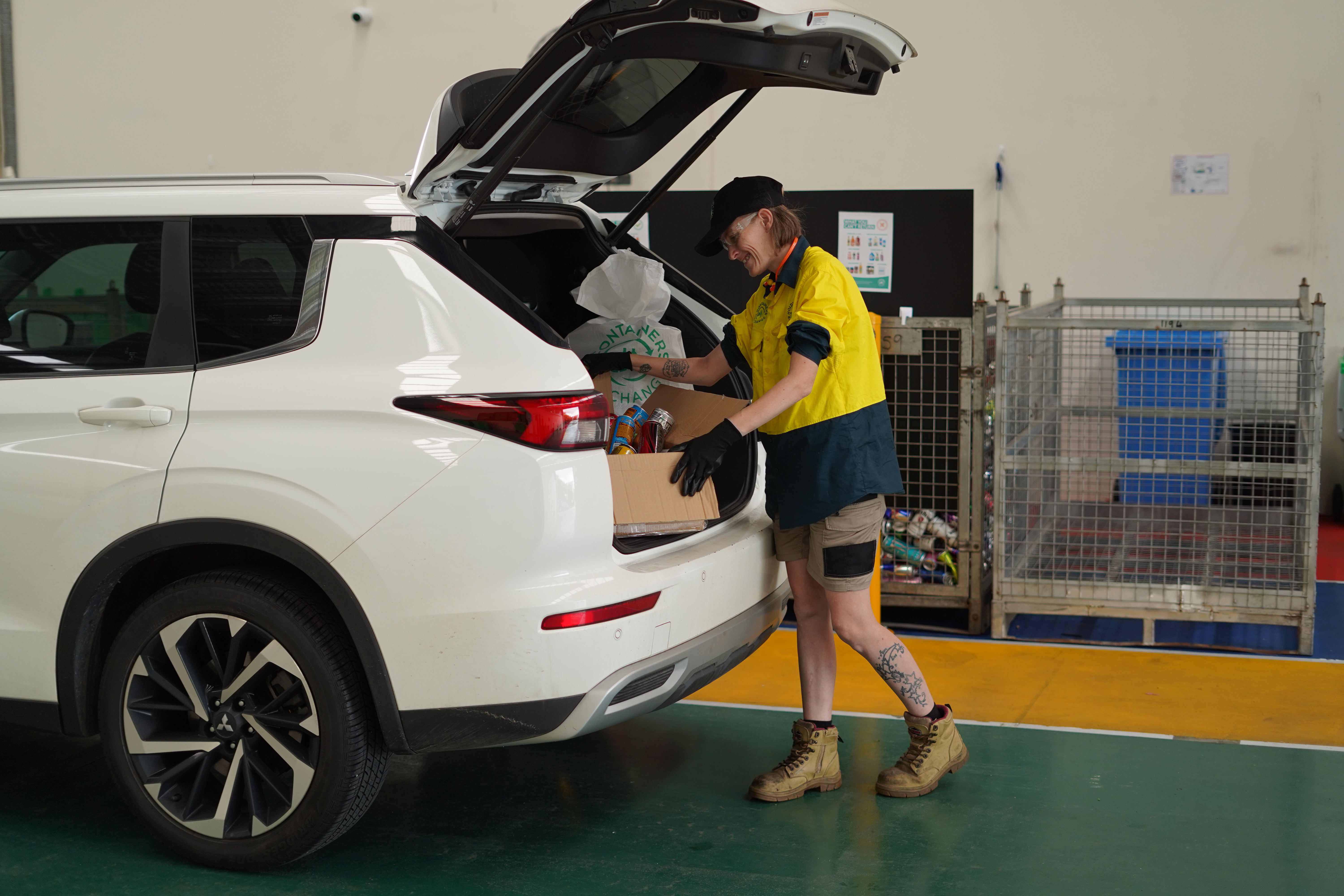 worker collecting containers at containers for change depot from a customer's car