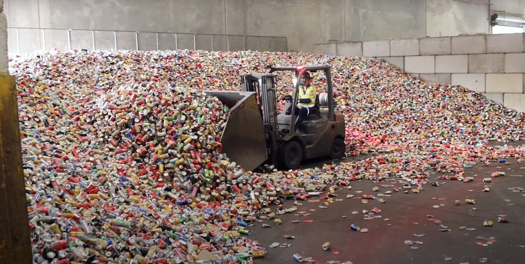 Aluminium cans with bobcat driving through 