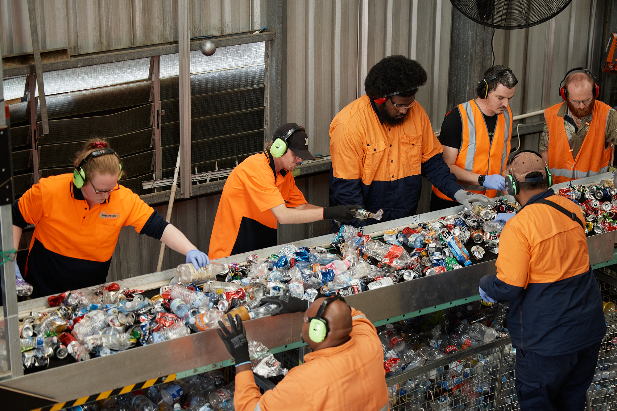 People sorting containers on a conveyor belt