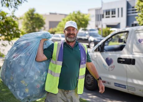 Man holding plastic bag of drink containers