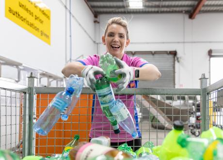Janelle holding bunch of empty plastic bottles 