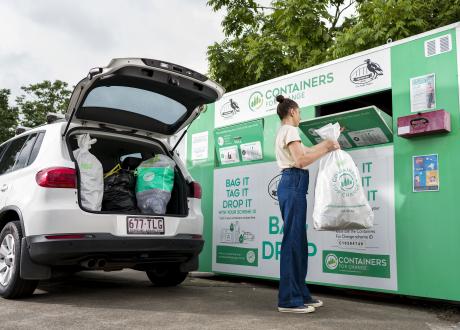 Lady using Containers for Change bag drop 