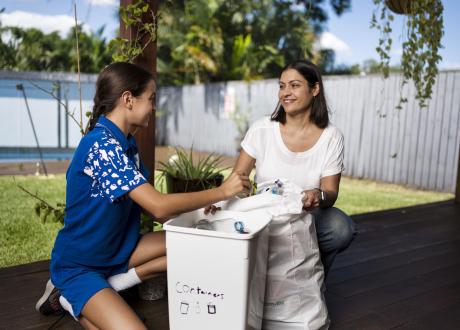 Woman and girl recycling containers