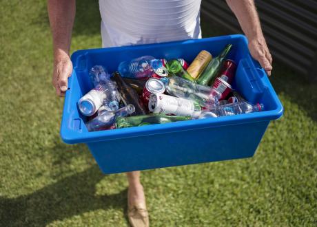 Man carrying tub of mixed drink containers