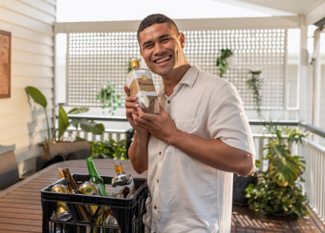 Man holding rum bottle on balcony