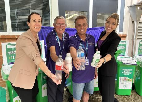 4 people holding bottles to camera