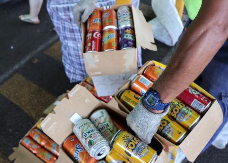 Person holding carton of softdrink cans