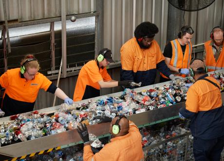People sorting containers on a conveyor belt
