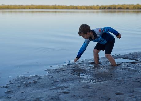 Little boy collecting rubbish on the beach