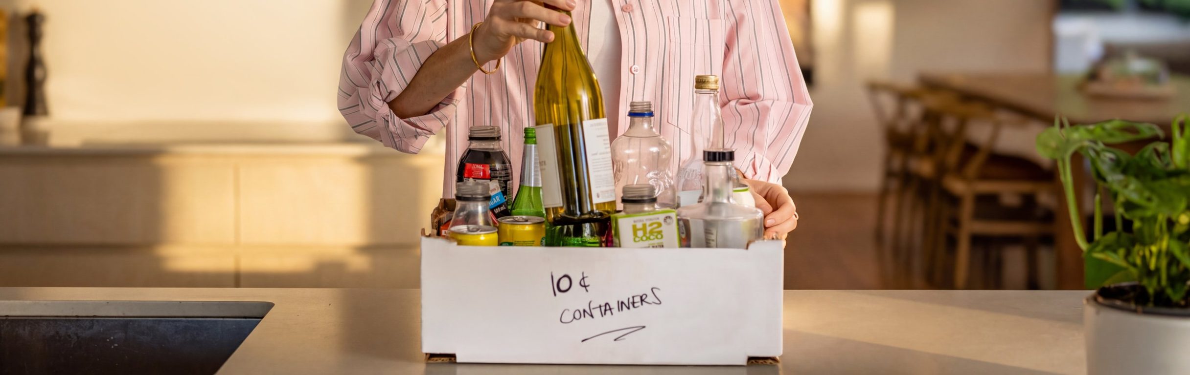 woman adding her 10c containers to her collection box